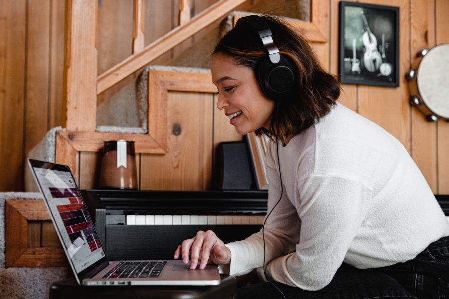 Women with headphones in front of a computer